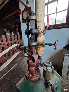 Flat belt attached to the red painted governor, pressure gauge in the background