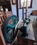 Spoked fly wheel has wide flat rim and axle for attaching the flat belt