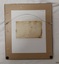Brown paper backing sheet with attached label showing an inscription