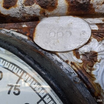 Oval plate with inscribed ID number, installed above the face