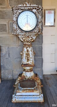 Upright metal scale with round face, coil slot and weighing platform
