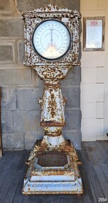 Upright metal scale with round face, coil slot and weighing platform
