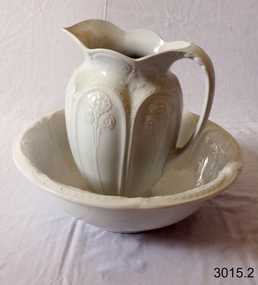 Jug and bowl are both cream-white ironstone and have matching, embossed, floral patterns