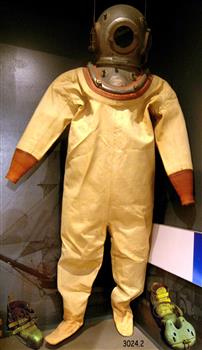 A yellow coloured diving suit with helmet and heavy weight boots. Weight has a buckle and fixing ring on the front.
