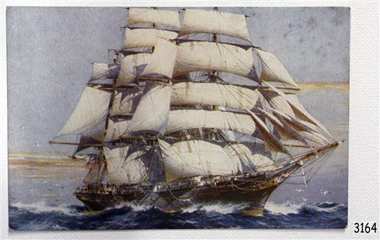 The coloured postcard shows a tall, fully rigged ship, close to land.