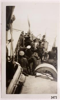Group of injured and able men on board a ship at sea.