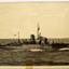 Black and white image of a ship on open sea travelling towards the right side of the image
