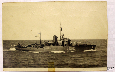 Black and white image of a ship on open sea travelling towards the right side of the image
