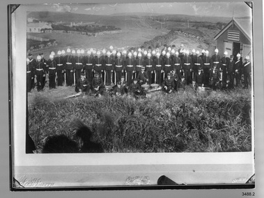 Black and white group photograph of Volunteer Corps Band with instruments. Inscriptions below it.