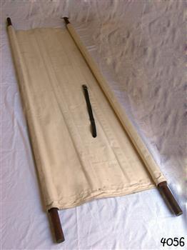 Two wooden poles threaded through hems each side of  cream canvas 