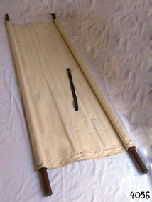 Two wooden poles threaded through hems each side of  cream canvas 