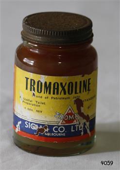 A small brown coloured bottle, with a yellow, red and blue label with the brand name in a white font, with a metal lid.