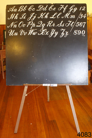 Blackboard and easel with Aa - Zz in copperplate in capitals and lowercase written on the board.