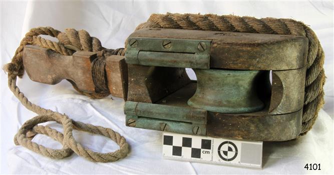Wooden block with metal sheave and short length of rope attached