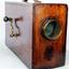 A rectangular box shaped fogforn made of a dark timber, with glass light in the front and a brass winder to make the sound. 