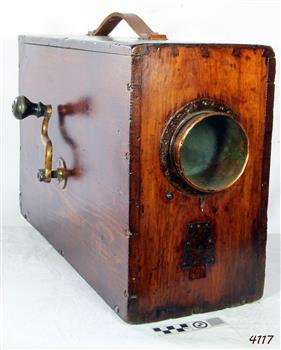 A rectangular box shaped fogforn made of a dark timber, with glass light in the front and a brass winder to make the sound. 