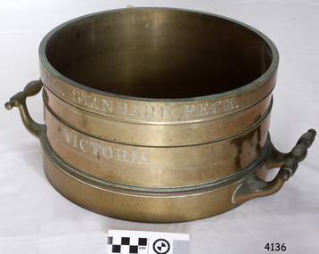Brass cylindrical vessel with two handles and engraved text