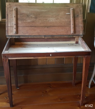 Hinged lid is open and reveals a storage space and a keyhole
