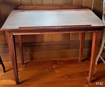 Wooden desk with sloping top and pencil ledge across the front