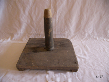 Wooden quoit base with vertical rod at centre.