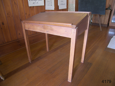 Wooden desk with angled lid opening from above.