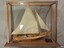 Wooden ship with two sails, mounted in a glass case with wooden frame, Two plaques included.