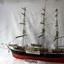 Model sailing ship with black and red hull and three masts
