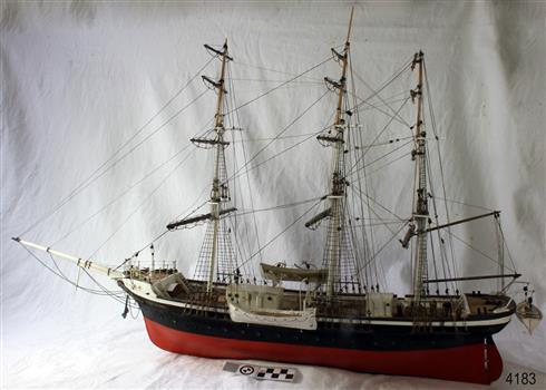 Model sailing ship with black and red hull and three masts