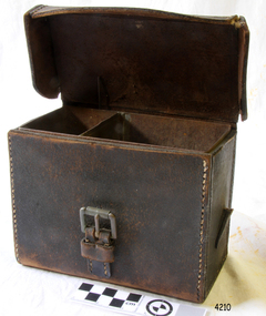 Brown leather rectangular case with  contrasting stitching, buckle closure, remnants of carrying strap