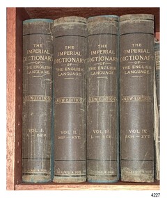 Four upright volumes bound in brown with gold embossed titles on the spine