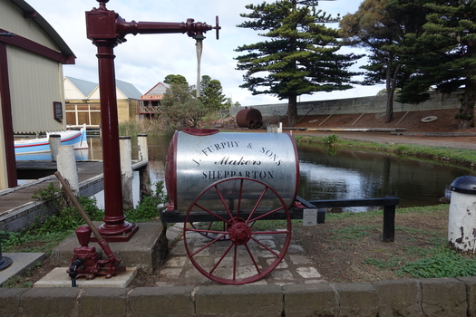Pump in front of standpipe and beside the Furphy water cart into which the water flows