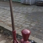 Pump is bolted firmly to timber base. Water pipes are connected to the pump. Timber handle is upright.