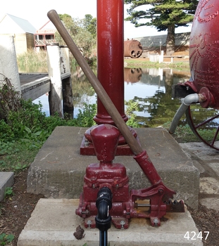 Pump has the base of the standpipe in the background, and the rear of the water cart beside it