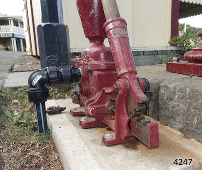 Pump base with maker's plate above on the handle. Metal teeth on the handle and base allow the pump to work