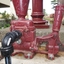 Modern plumbing fittings are attached to the early-to-mid 20th century pump, allowing it to be used as part of the display
