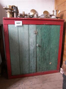 Small wooden cupboard with vertical panel doores, painted green with red trim