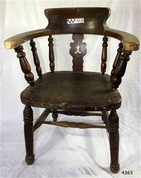 Wooden chair has curved back and armrests, turned spindles and legs