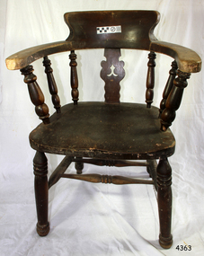 Wooden chair has curved back and armrests, turned spindles and legs