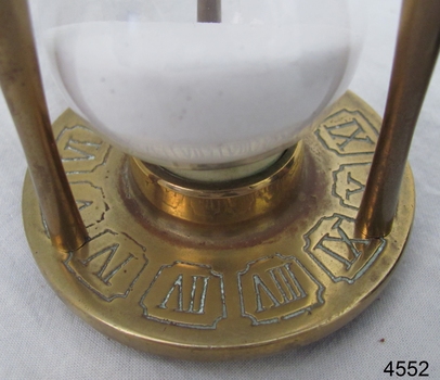 Inscriptions and patterns in the metal bas of the hourglass