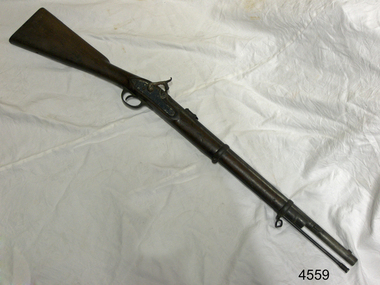 Metal and wood gun on a bench, viewed from above
