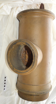 Brass pump section with screw tread at the base and timber from the ship attached