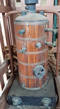 Vertical boiler with wood planking, brass fittings and bands and metal firebox with pull-down door