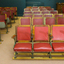 Sixteen banks of red leather covered chairs on wood and metal frames
