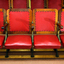 Bank of seats with backrests and seats covered in red leather
