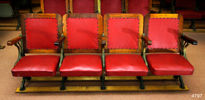 Bank of seats with backrests and seats covered in red leather
