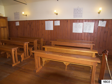 Made from solid wood in a simple design. Each desk and bench seats four students. Four inkwells on each desk.