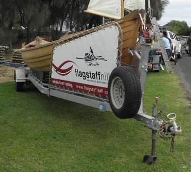 Whaleboat mounted on a trailer, with sail in place