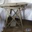 Grey metal machine with square top and treadle foot pedal