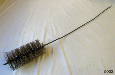Twisted wire handle with stiff bristles on the end, arranged in a cylindrical shape