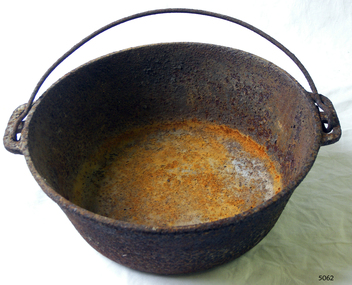 Round deep metal cooking pot with large handle. Very rusty. 